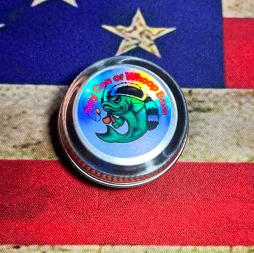 Tiny Can of Whoop Bass Version 2.0 shown sealed, front label visible, pocket‑sized survival fishing kit.