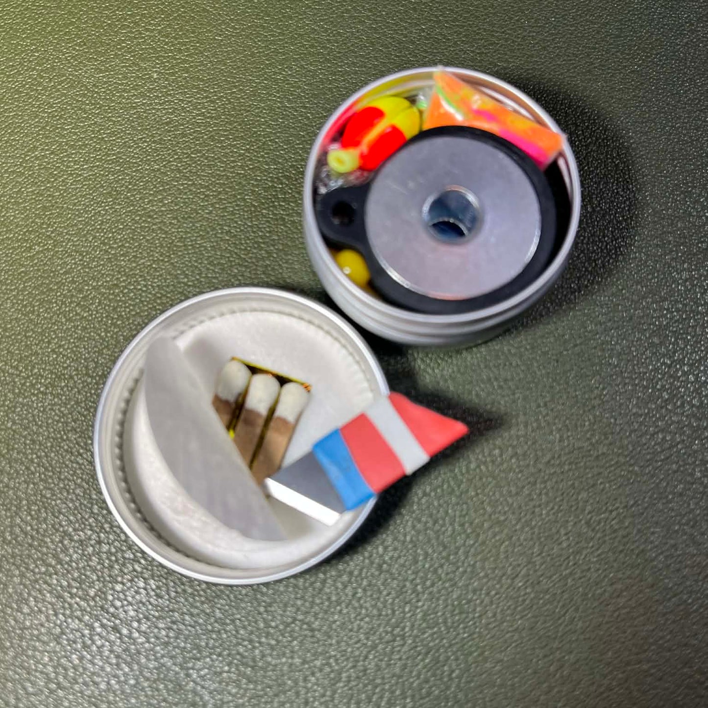 Mini knife used as a pry tool to peel back tape and reveal the hidden matches inside the tightly packed can