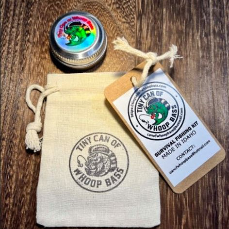 Drawstring bag with the new Tiny Can of Whoop Bass logo stamp, shown alongside the sealed can and attached string label, displayed together as the complete packaging set.