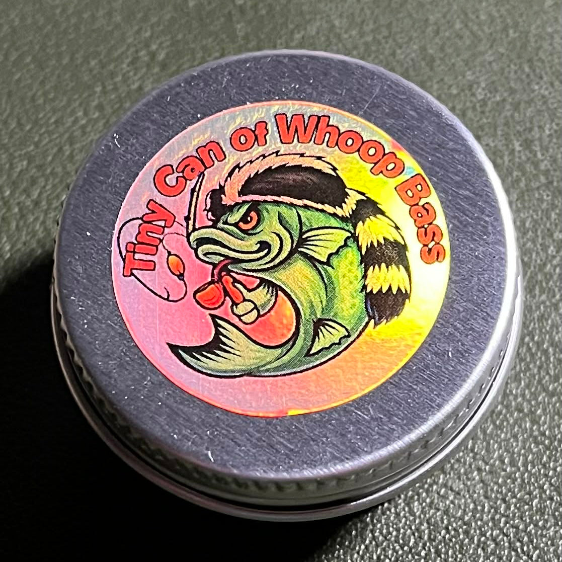 Small fishing‑kit can shown in a close‑up with the new Whoop Bass logo